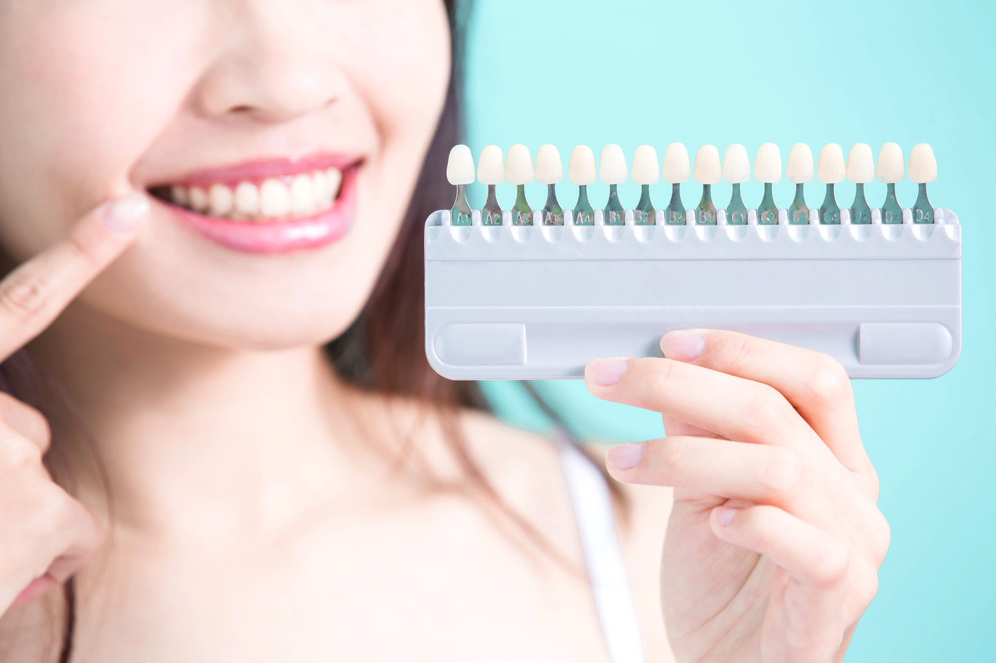シェードガイドを手に笑顔の女性